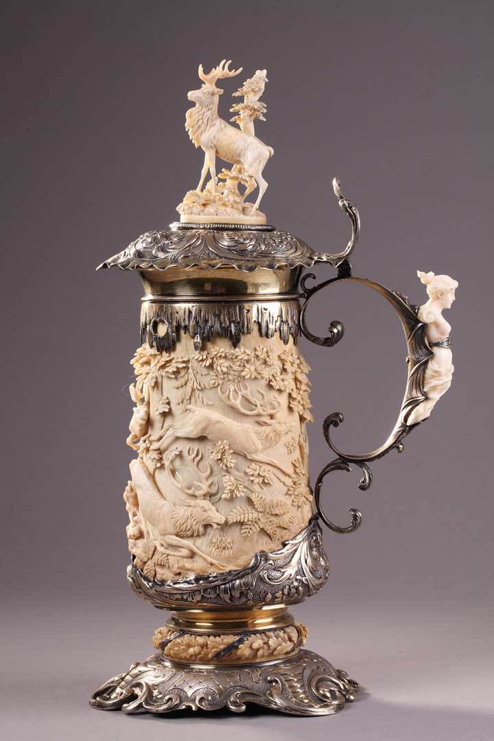 A SILVER MOUNTED RELIEF CARVED IVORY TANKARD